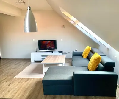 a living room with a blue couch and a tv at ,,Адела”-апартамент за гости in Velingrad