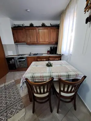 a kitchen with a table and two chairs and a table and a kitchen at Winslow Highland Bansko - Apartment Giovanni, ул Валевица 7 кв Грамадето in Bansko