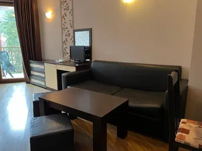 a living room with a couch and a table at Стаи и апартаменти под наем in Borovets