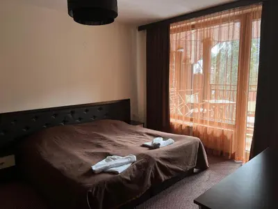 a bedroom with a bed with two towels on it at Стаи и апартаменти под наем in Borovets