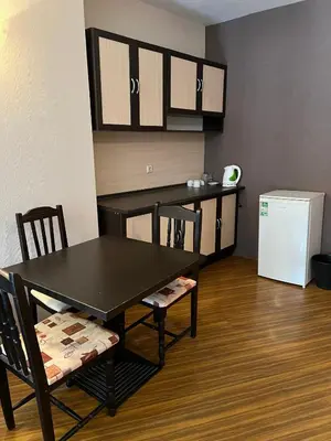a kitchen with a table and chairs and a refrigerator at Стаи и апартаменти под наем in Borovets