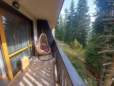 a porch with a rattan swing on a balcony at 1 Bedroom cozy flat in Pamporovo