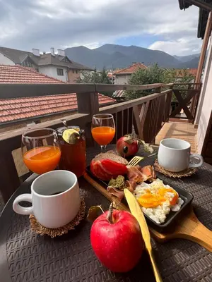 a tray of breakfast food on a table on a balcony at Honey House in Bansko