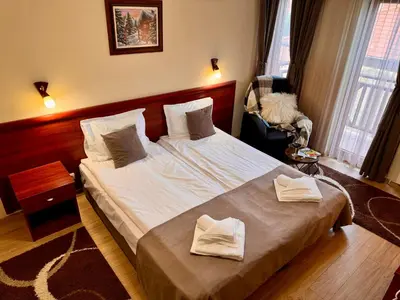 a bedroom with a large bed with towels on it at Honey House in Bansko