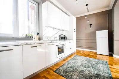 a kitchen with white cabinets and a large window at 2bdr Luxury On Prime Location in Sofia