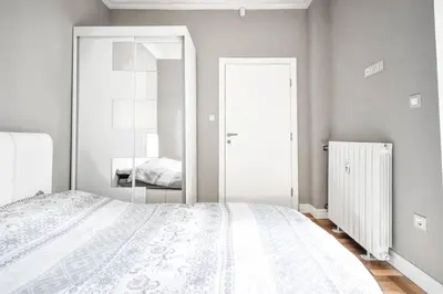 a bedroom with a white bed and a mirror at 2bdr Luxury On Prime Location in Sofia