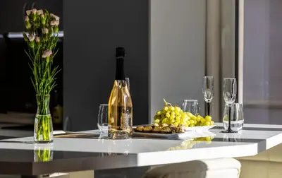 a bottle of wine sitting on a table with wine glasses at Modern 1BD Flat with a Parking near the city centre by Flat Mаnager in Plovdiv