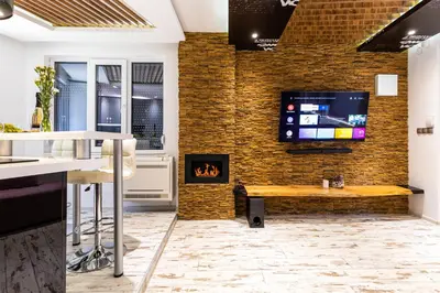 a kitchen with a fireplace and a tv on a brick wall at Modern 1BD Flat with a Parking near the city centre by Flat Mаnager in Plovdiv