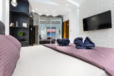a bedroom with a large bed with a tv on the wall at Modern 1BD Flat with a Parking near the city centre by Flat Mаnager in Plovdiv