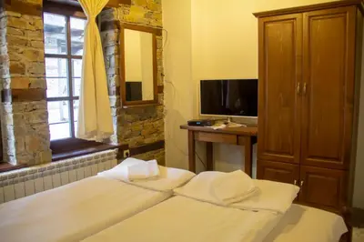 a bedroom with a bed and a desk and a television at Leshtenski Rai Guest House in Leshten