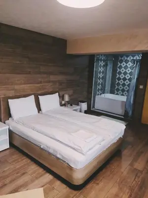 a bedroom with a large bed and a window at Leshtenski Rai Guest House in Leshten