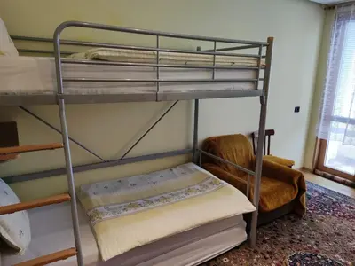 a bunk bed in a room with a chair at Rila Apartment in Samokov