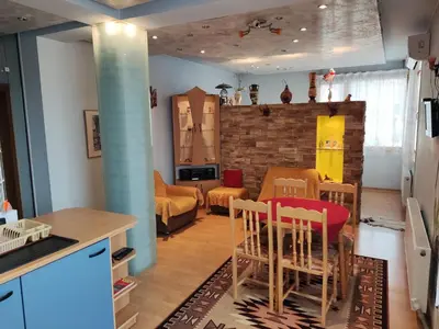 a kitchen and living room with a table and chairs at Rila Apartment in Samokov