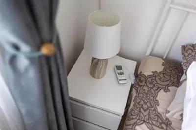 a bedside table with a lamp and a phone on it at Karastoyanovi's Apartment in Sofia