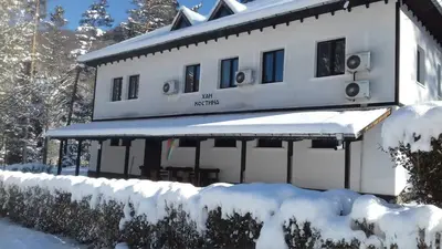 a building covered in snow with snow covered bushes at ХАН КОСТИНА - HAN KOSTINA in Ribarica
