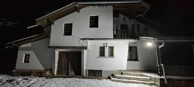 a white house in the snow at night at ХАН КОСТИНА - HAN KOSTINA in Ribarica