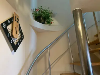 a spiral staircase with a potted plant on the wall at Bansko Ski to Door Apartment in Bansko