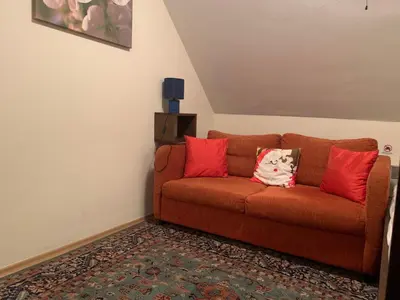 a living room with a brown couch with red pillows at Bansko Ski to Door Apartment in Bansko