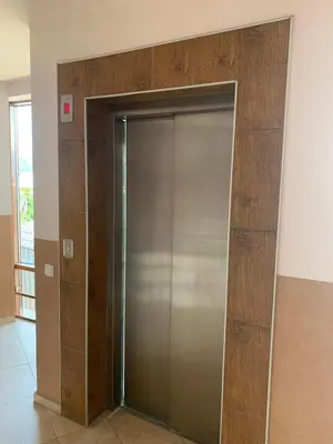 a metal elevator door in a room with a wall at Bansko Ski to Door Apartment in Bansko