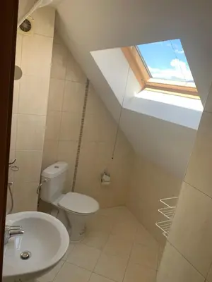 a bathroom with a toilet and a window at Bansko Ski to Door Apartment in Bansko