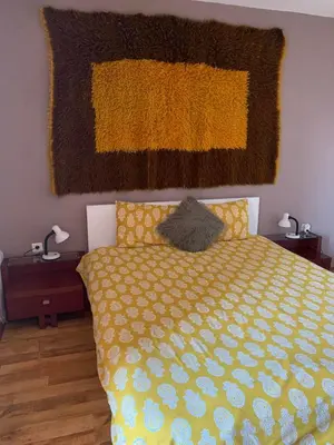 a bedroom with a bed with a yellow comforter at Bansko ski apartment Mountain View Resort in Bansko