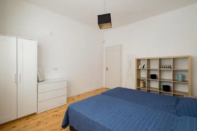a white bedroom with a blue bed and a white cabinet at Spacious 3 Bedroom Home in Sofia's Top Center in Sofia