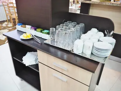 a counter with plates and cups and dishes on it at Тайната квартира - The Secret apartment in Pamporovo