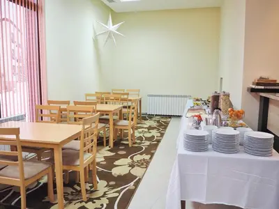 a dining room with tables and chairs with plates on it at Тайната квартира - The Secret apartment in Pamporovo