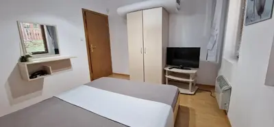 a small room with a bed and a television at NordenPamporovo in Pamporovo