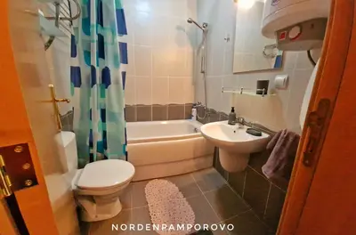 a bathroom with a toilet and a sink and a tub at NordenPamporovo in Pamporovo