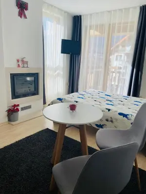 a room with a table and a bed and a tv at Studio Chalet 13, St John Park Bansko in Bansko