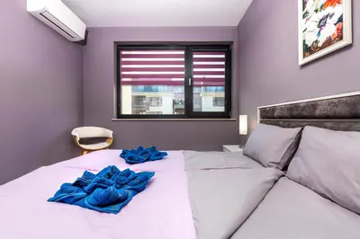 a bedroom with a bed with blue sheets and a window at Stylish 1BD flat with a Parking Spot by Flat Mаnager in Plovdiv