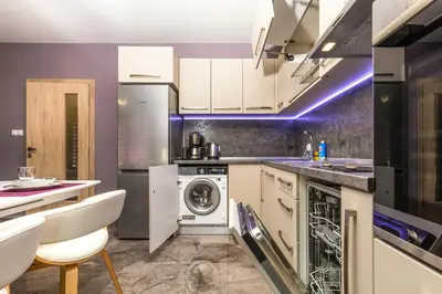 a kitchen with white cabinets and a washer and dryer at Stylish 1BD flat with a Parking Spot by Flat Mаnager in Plovdiv