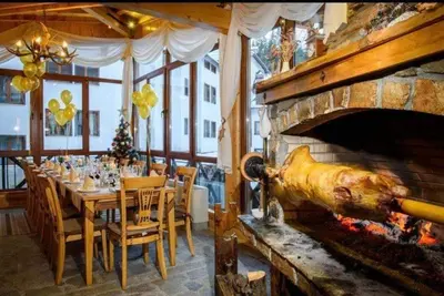 a dining room with a table and a fireplace at Pamporovo Apartment The Castle in Pamporovo