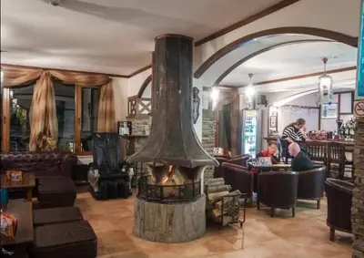 a restaurant with a large fireplace in a room at Pamporovo Apartment The Castle in Pamporovo