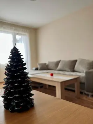 a christmas tree sitting on a table in a living room at Prime Apartments in Bansko