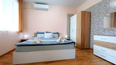 a bedroom with a king sized bed and a brick wall at Prime Apartments in Bansko