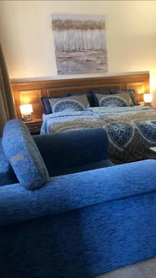 two beds in a room with blue sheets and pillows at Luxury studio in Bansko