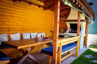 a wooden patio with a wooden table and chairs at Villa Boro in Beli Iskar