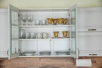 a glass cabinet filled with dishes and glasses at Bansko Ski Apartment in Bansko