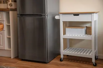 a cart next to a refrigerator in a kitchen at Bansko Ski Apartment in Bansko