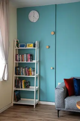 a book shelf with books and a clock on a wall at Bansko Ski Apartment in Bansko