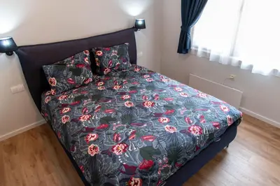 a bedroom with a bed with a floral comforter at Bansko Ski Apartment in Bansko