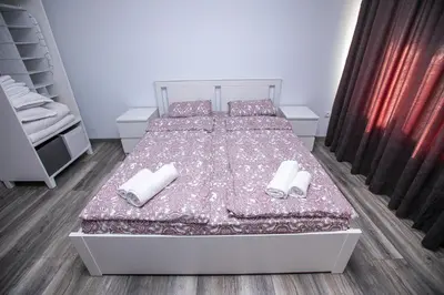 a bedroom with a bed with two white towels on it at Aparthouse Heaven in Sandanski