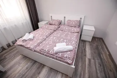 a bedroom with a bed with shoes and towels on it at Aparthouse Heaven in Sandanski