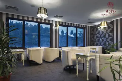 a restaurant with white chairs and tables and windows at Апартамент Лукс в Спа Хотел Свети Спас in Velingrad