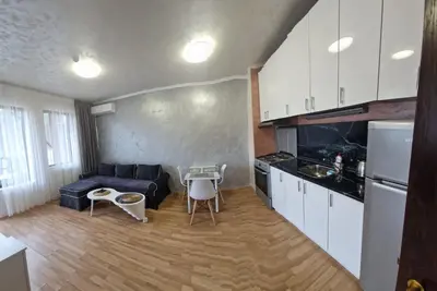 a kitchen and a living room with a couch and a table at Апартамент Лукс в Спа Хотел Свети Спас in Velingrad