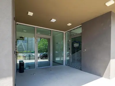 an external view of a building with glass doors at Modern Apartment 2 with Parking next to Bulgaria Mall in Sofia