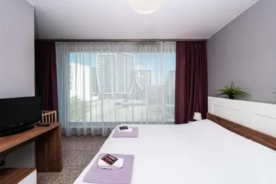 a hotel room with a bed and a large window at Modern Apartment 2 with Parking next to Bulgaria Mall in Sofia