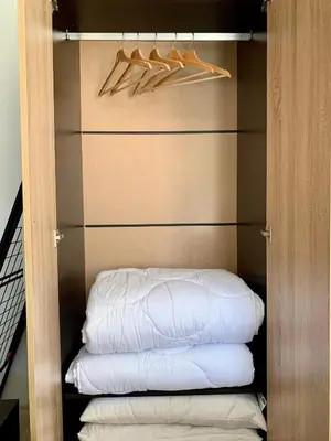 a closet with a stack of white pillows and hangers at Premium Apartments Bansko in Bansko
